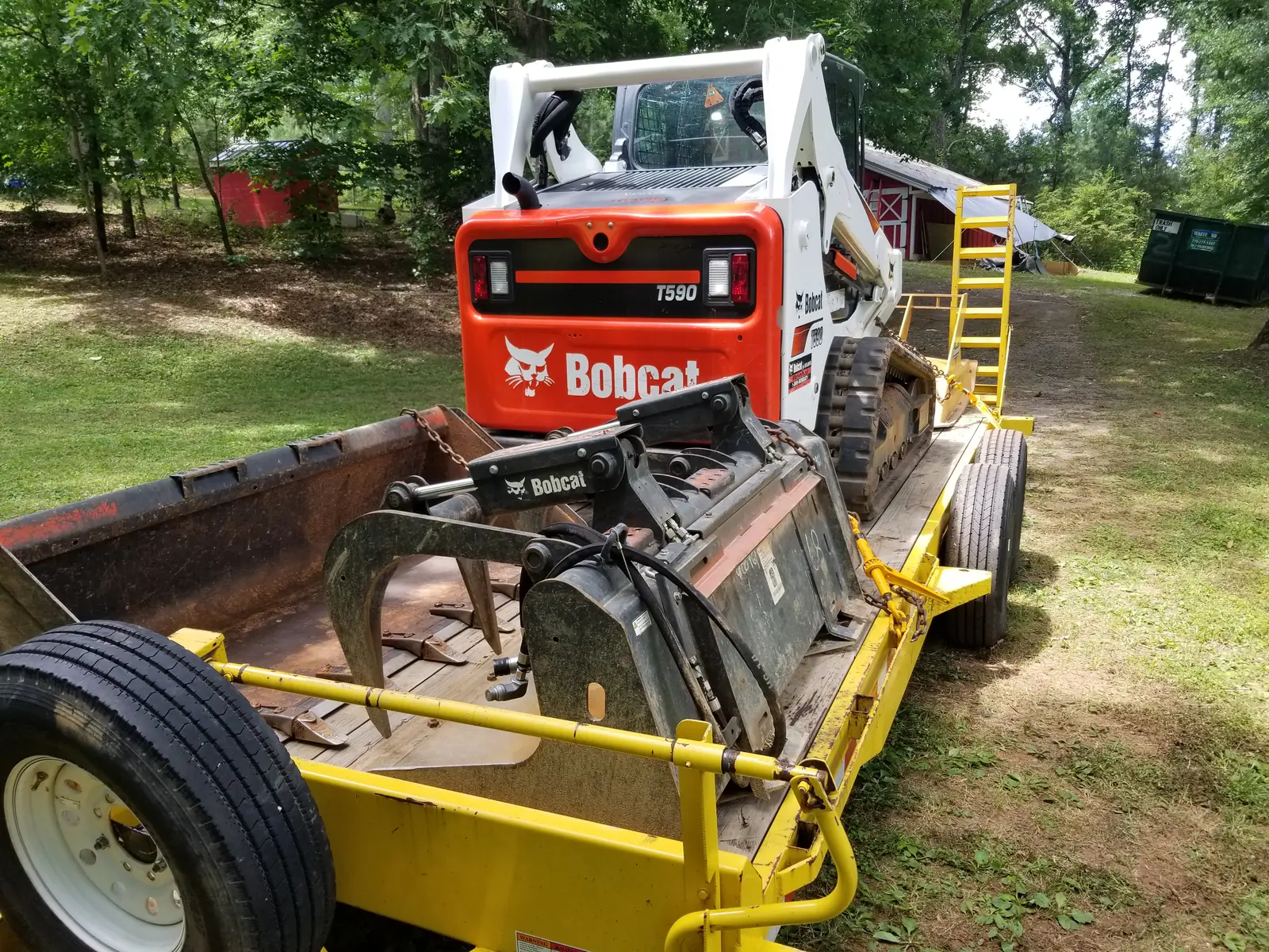 The company's Bobcat T590 with a forestry mulcher on its trailer
